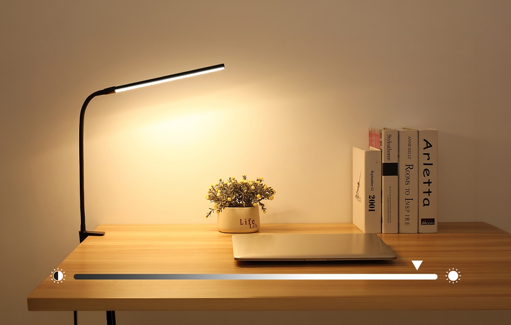 A lamp illuminating the desk; underneath is a graphic with a brightness control slider.