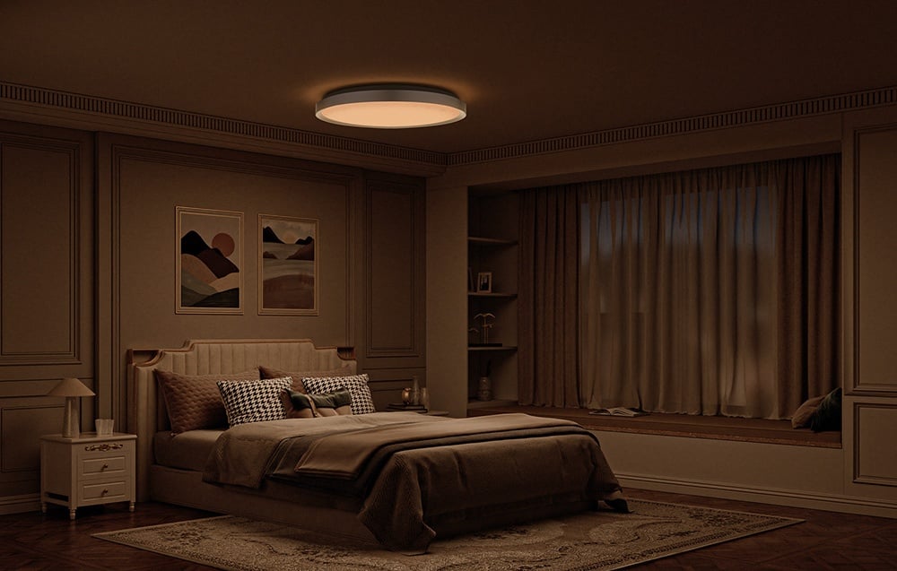 A cozy bedroom in warm tones with a bed and a Yeelight Jupiter D C600 lamp shining a soft, warm light.
