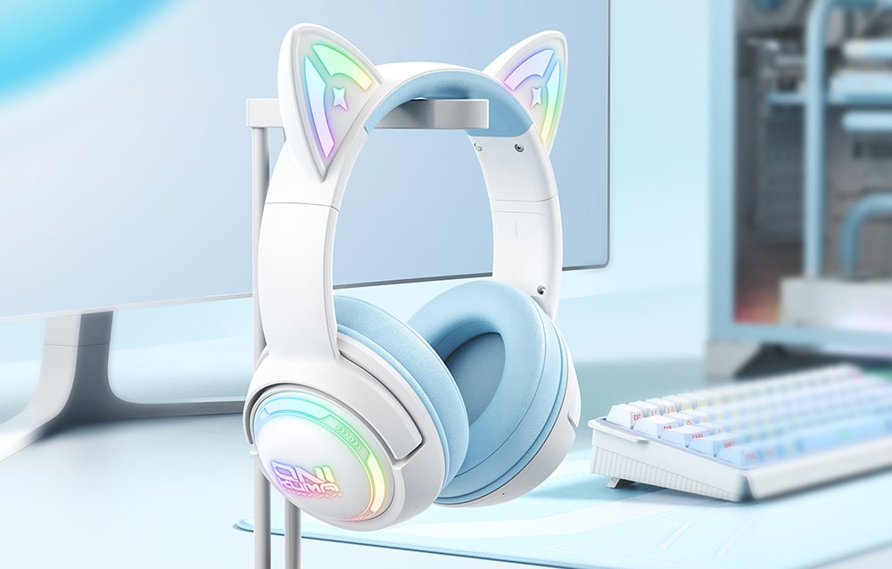 Onikuma headphones with cat ears hanging on the bracket next to the keyboard and monitor
