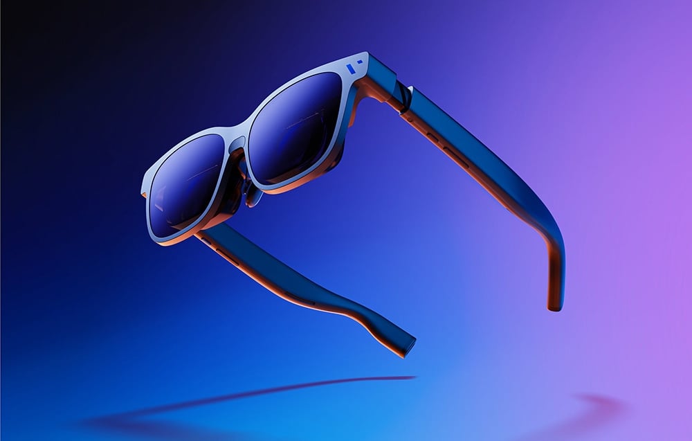 Stylish black glasses float in the air against a background transitioning from purple to blue.