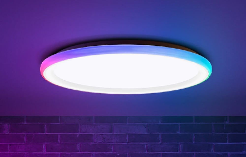 Yeelight Mars C300 ceiling lamp shining white and colored light against a brick wall.