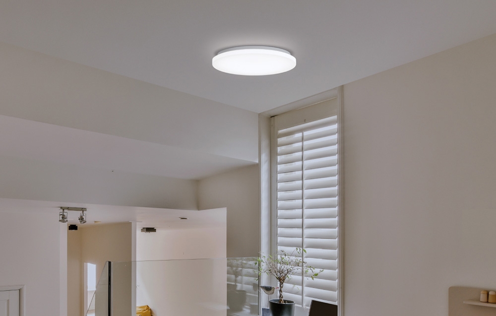 Yeelight MercuryE C260 lamp mounted indoors with vertical blinds and a pot on the windowsill.