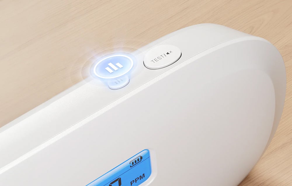 Close-up of the TEST and pause buttons on top of the X-Sense carbon monoxide detector