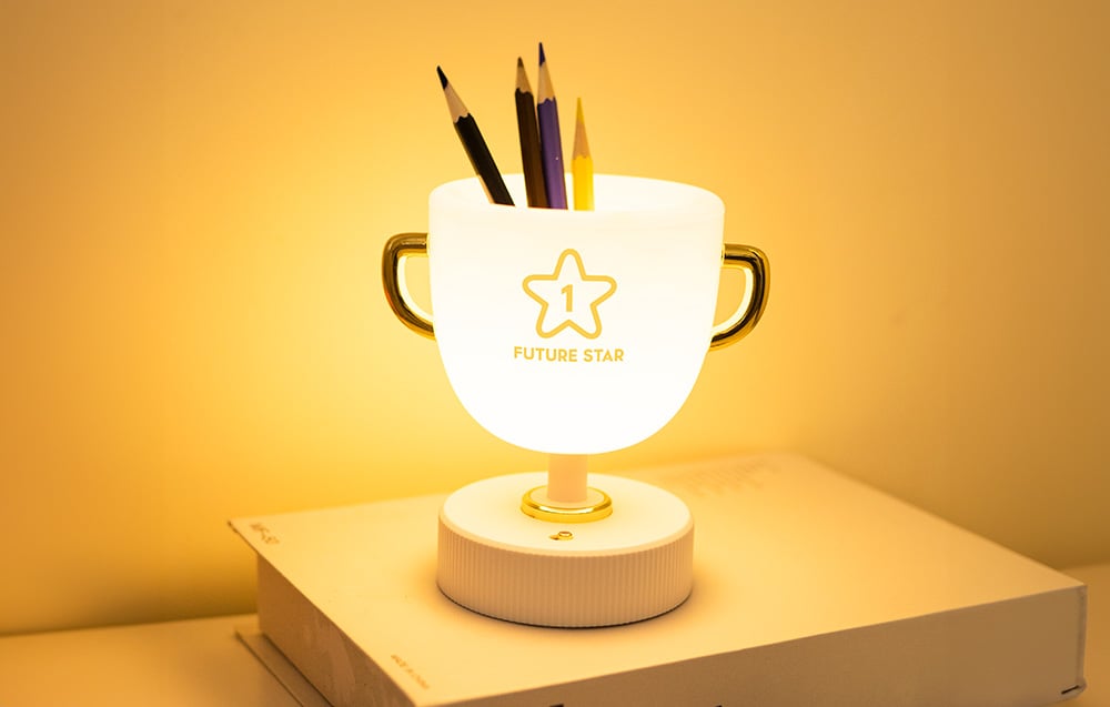 SuperFire W-006 Champion Light bedside lamp in use as an organizer. The device shows 4 crayons in different colors.