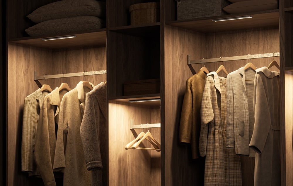 Yeelight closet light mounted under the top of the wooden closet illuminating the clothes on the hangers.