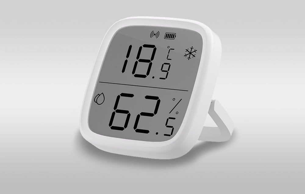 A white temperature and humidity sensor on a light gray background