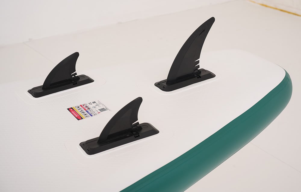 Close-up of 3 black fins on a surfboard