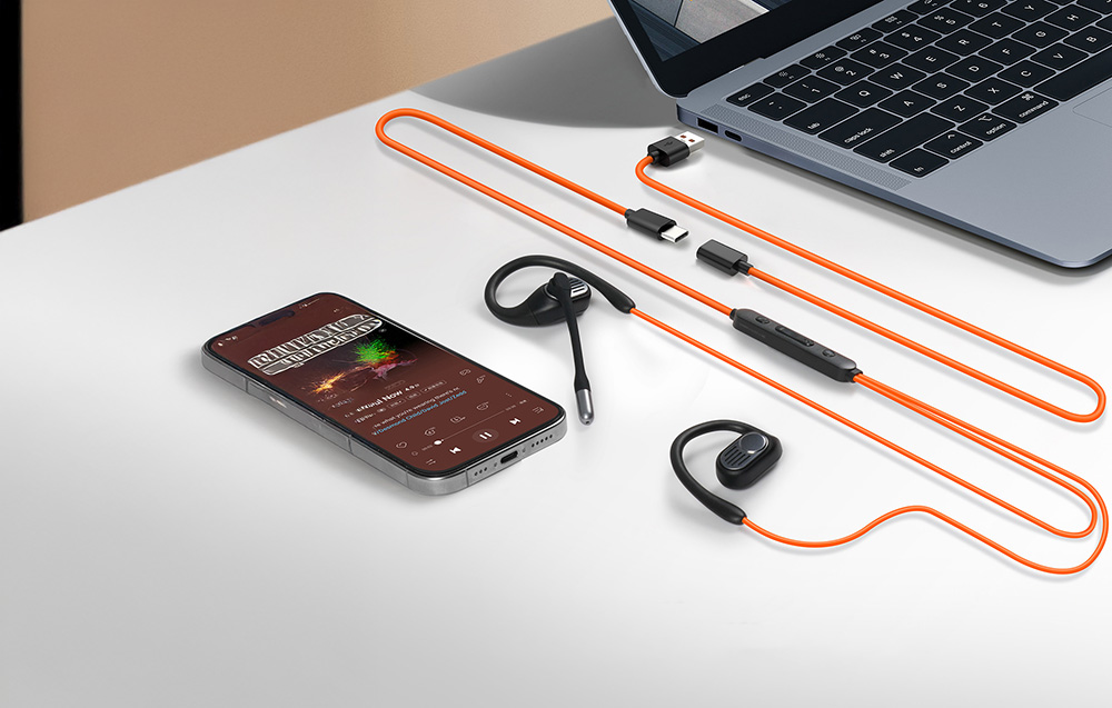 Smartphone, wired headphones with microphone and laptop on white desk