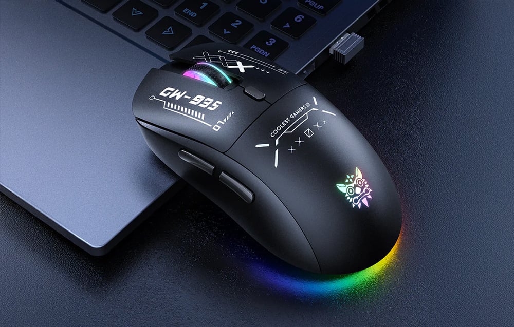 Black gaming mouse with colorful backlighting based on a laptop on a dark background