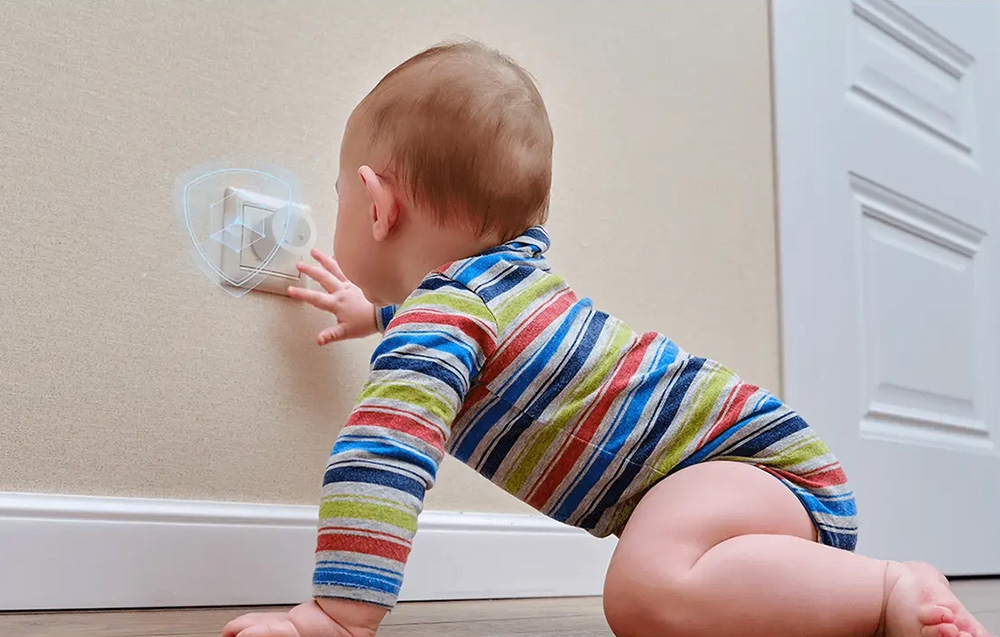 A baby crawls across the floor toward the outlet with the plug inserted, above which a dial icon is visible