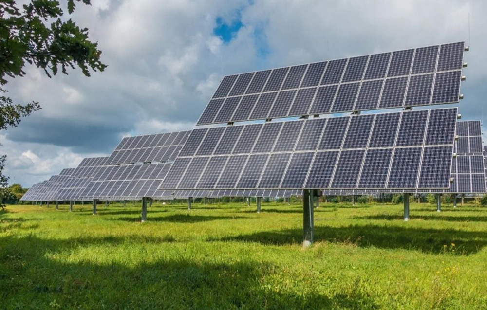 Solar panel structures mounted on grass under a cloudy sky