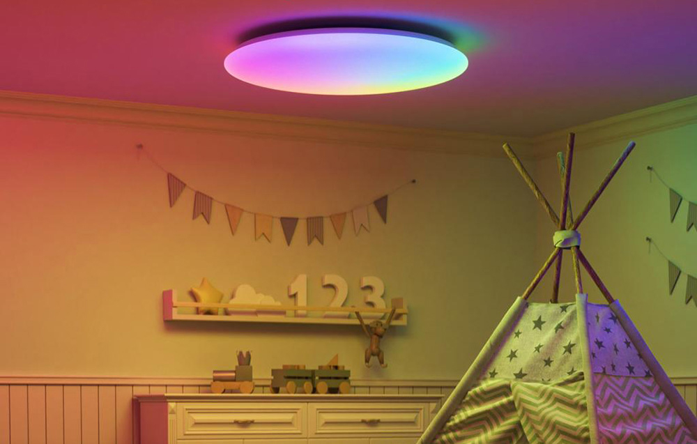 Kolorowa sufitowa lampa LED w dziecięcym pokoju z namiotem tipi i dekoracjami na ścianie.