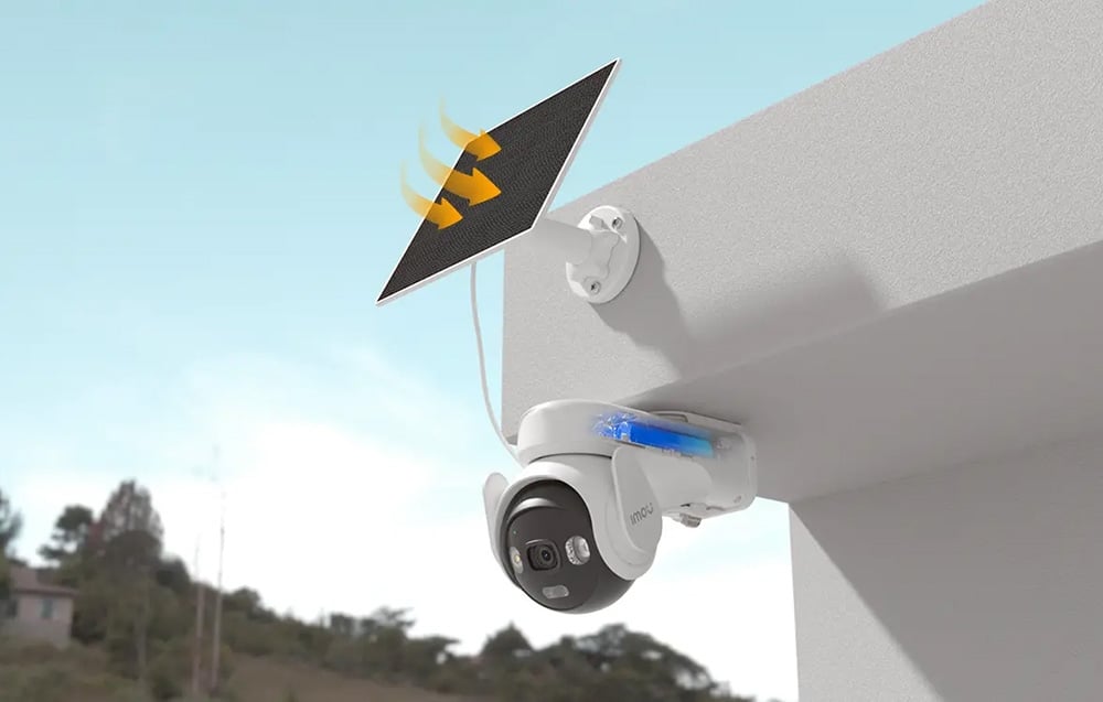 Camera mounted under a visor with a visible blue battery inside; above it, a solar panel and yellow arrows