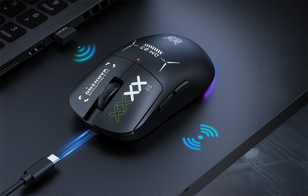 Black Onikuma computer mouse with cable next to a laptop