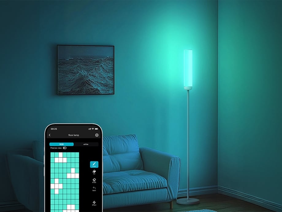 A smartphone with a lighting control app open, set against the backdrop of a room featuring a turquoise-glowing column lamp.