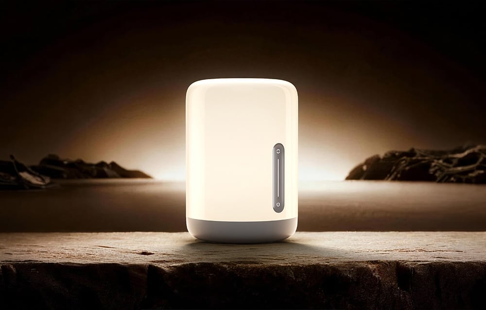 A nightlight turned on, placed on a raw stone surface against the backdrop of a dark landscape