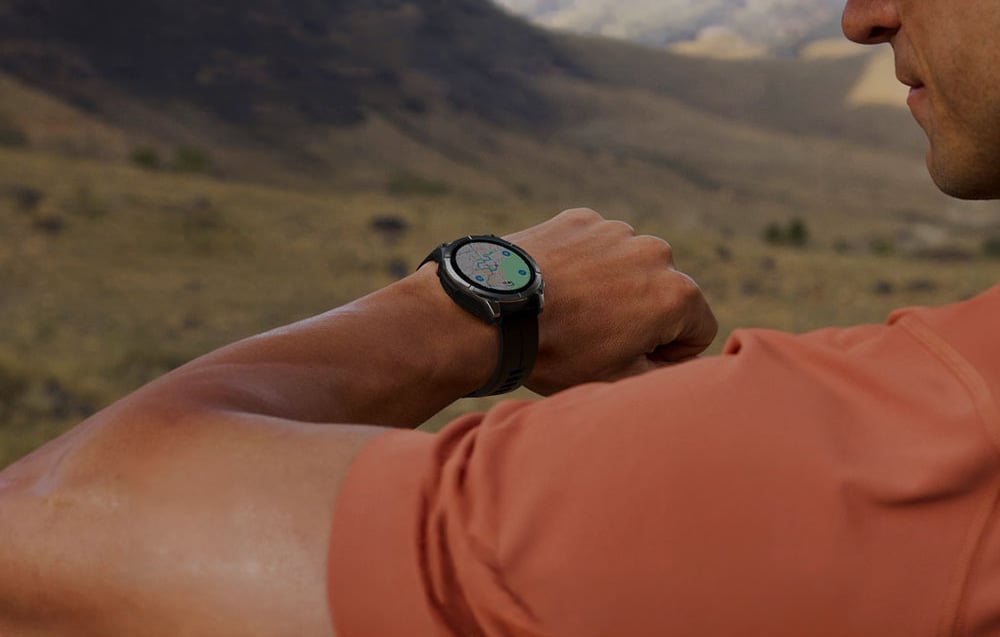 A man checking navigation with a map on his smartwatch screen while out in the field