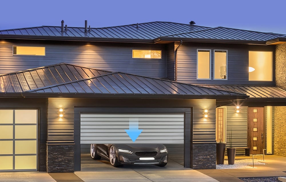 Modern house with garage door open and car inside at dusk